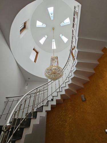 a staircase with a clock and a chandelier at Homestay near Kochi Airport in Ernakulam