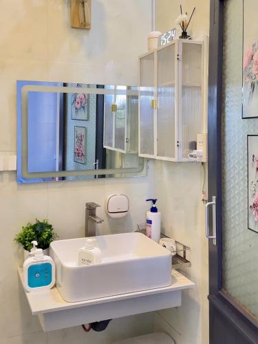 a bathroom with a white sink and a mirror at SIM House in Thôn Trường Giang