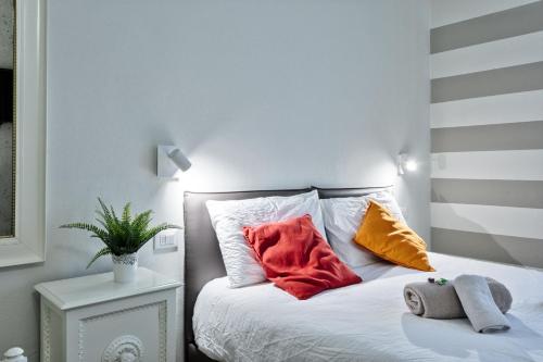 a bed with red and yellow pillows on it at CAMERA TUA - Padova Centro & Ospedale in Padova