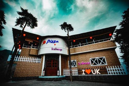 a pizza hut building with a palm tree in front of it at Iceberg Hill View in Mussoorie