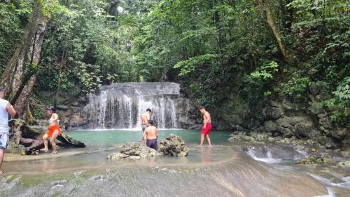 a group of people standing in the water in a waterfall at Tortugal Boutique River Lodge in Rio Dulce