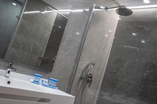 a bathroom with a shower and a sink and a mirror at Hotel Olimpo in Isla