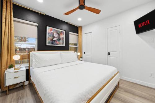 a bedroom with a white bed and a ceiling fan at Peaceful 1-BR Stay w/ Putting Green near Downtown in Oak Cliff