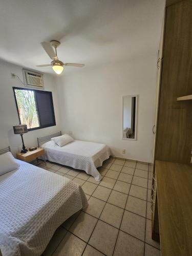 a bedroom with two beds and a ceiling fan at Apto 337 - AgrishowShoppingFATESA in Ribeirão Preto