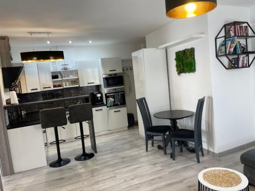 a kitchen with a table and chairs in a room at Apartmán SIA Garážové parkovanie in Poprad