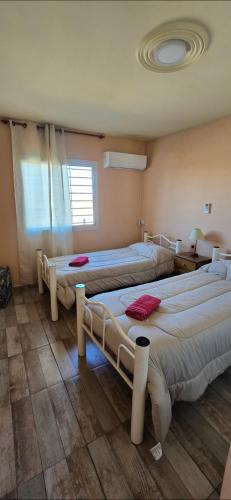 una habitación con tres camas y una ventana en Deseo de Montaña, en Maipú