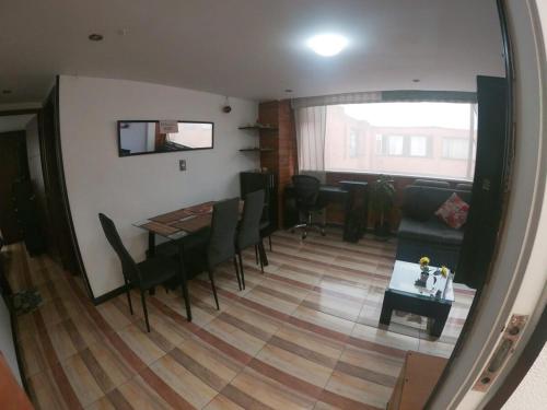 a living room with a table and chairs and a couch at Apartamento cerca al Aeropuerto in Bogotá