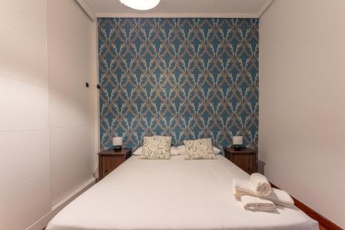 a bedroom with a bed and a blue wall at Tu hogar en Bilbao para 4 personas in Bilbao