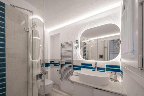 a white bathroom with a sink and a mirror at Villa Smeralda Punta Lada Porto Rotondo in Porto Rotondo
