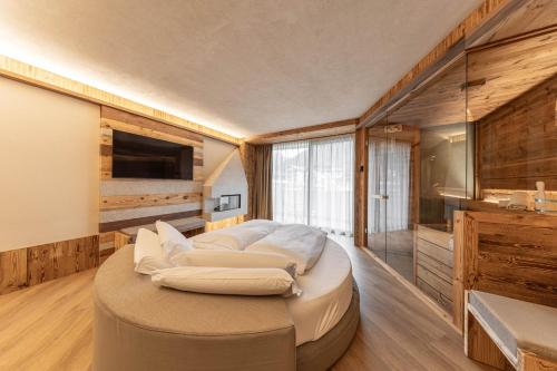a large white bed in a room with wooden walls at Hotel Mirabello - Slow Hotel Benessere in Fiera di Primiero