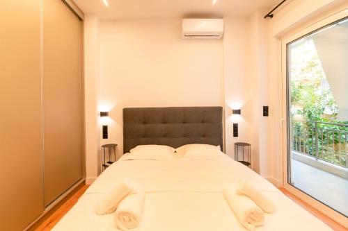 a bedroom with a large bed and a large window at Cozy 2-Bedroom by Flisvos Marina in Athens