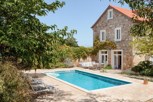 an external view of a house with a swimming pool at Villa Estelle, Hvar Island in Vrbanj