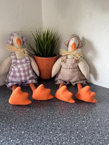 three stuffed animals sitting next to a potted plant at The Pigeon Hole in Ribe