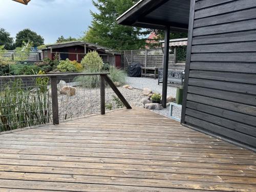 a wooden walkway next to a building with a fence at The Pigeon Hole in Ribe