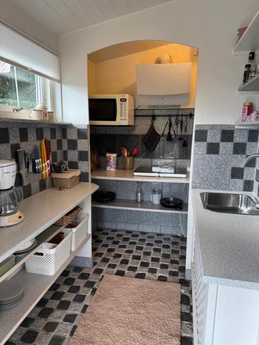 a kitchen with a sink and a microwave at The Pigeon Hole in Ribe