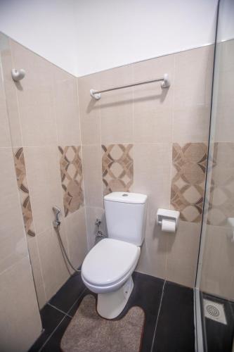 a bathroom with a toilet and a shower at The Cozy Nest - Sigiriya in Sigiriya