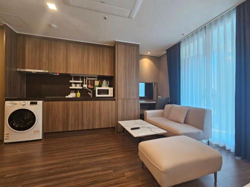 sala de estar con sofá y lavadora en Haeundae Elbon The Stay, en Busan