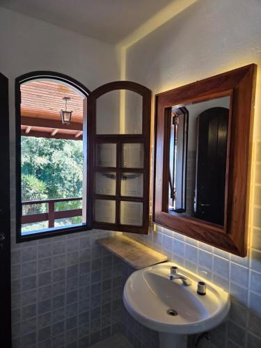a bathroom with a sink and two windows at Hotel Pousada Boa Montanha in Monte Verde