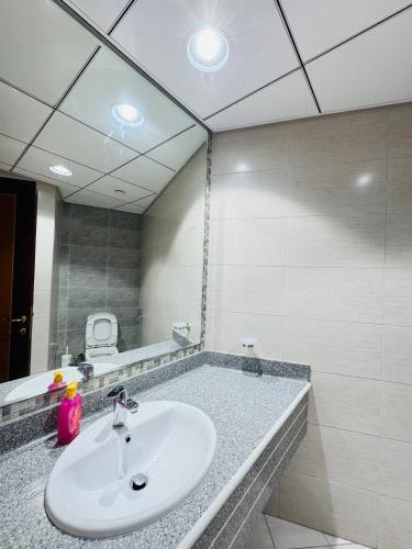 een badkamer met een wastafel en een grote spiegel bij Luxury 2Bed Room sea view in Ajman 