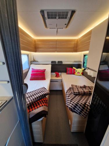 a small room with two beds in a trailer at Przyczepa ADORA nad morzem in Rumia