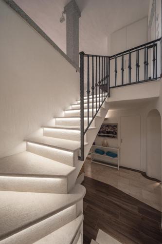 a staircase in a house with white walls and wooden floors at Villa Smeralda Punta Lada Porto Rotondo in Porto Rotondo