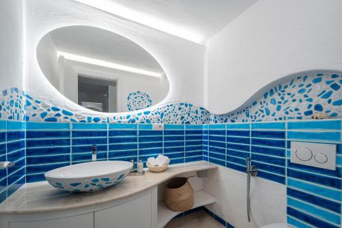 a blue and white bathroom with a sink and a mirror at Villa Smeralda Punta Lada Porto Rotondo in Porto Rotondo
