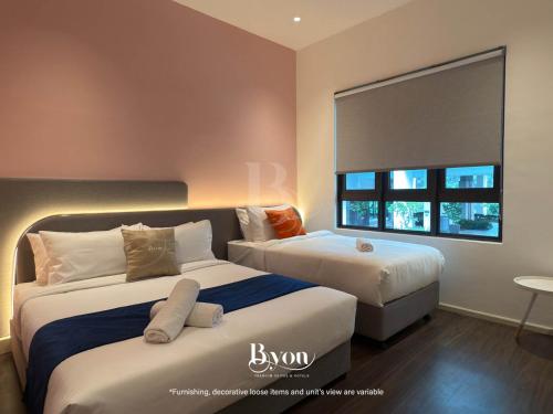 a hotel room with two beds and a window at Onsen Premium Suites @ Tambun Ipoh in Ipoh