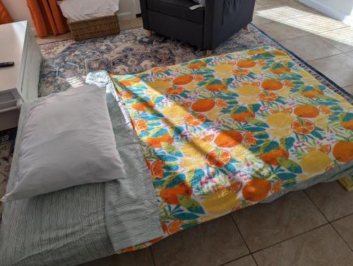 a bed with a blanket with oranges on it at Zesty Studio & Pet Friendly Yard in Modesto