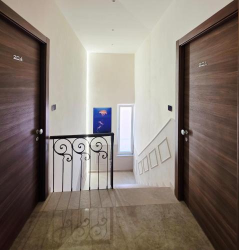 a hallway with two wooden doors and a staircase at HOTEL Mirarti in Rapallo