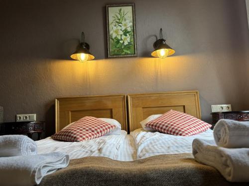 two beds sitting next to each other in a room at Pilsberģu krogs in Jūrkalne
