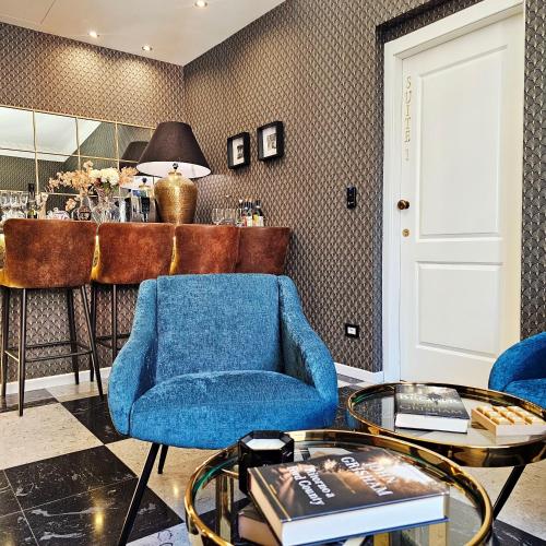 a living room with a blue chair and a table at STOA ROME Boutique Suites in Rome