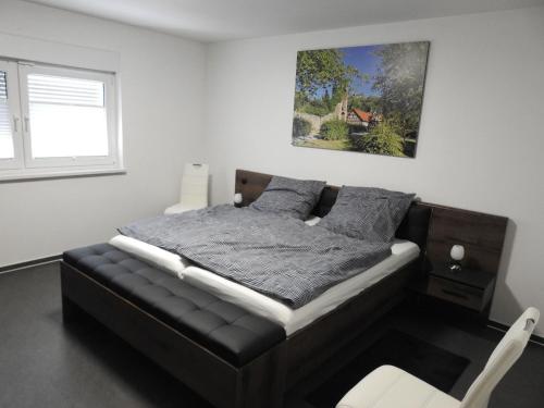 a bedroom with a bed and a picture on the wall at Ferienwohnung Am Fischerhof 10a Wernigerode in Wernigerode