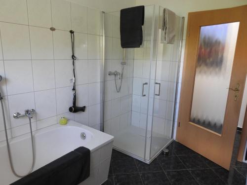 a bathroom with a shower and a tub and a sink at Ferienwohnung Am Fischerhof 10a Wernigerode in Wernigerode
