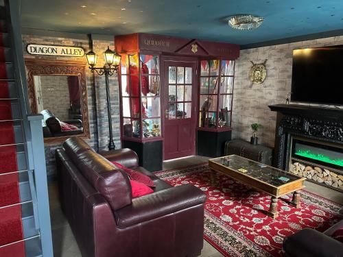 a living room with leather furniture and a fireplace at Quidditch Quarters Themed Property in Garston
