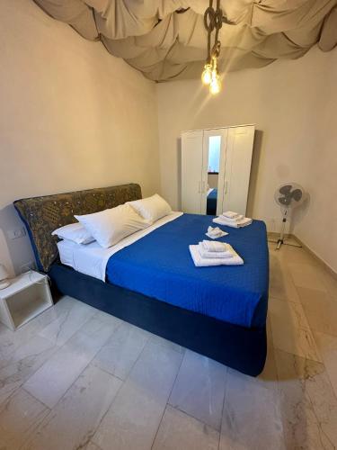 a bedroom with a blue bed in a room with a fan at La Casetta in Trapani