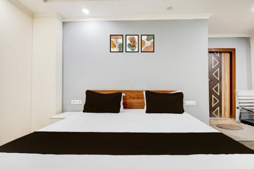 a bedroom with a large white bed with black pillows at HOTEL O BLUE DIAMOND STAY in Noida