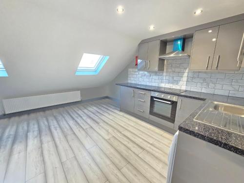 a large kitchen with wooden floors and a counter top at Bedroom in shared house in Hounslow in Hounslow