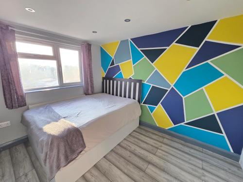a bedroom with a colorful mural on the wall at Bedroom in shared house in Hounslow in Hounslow