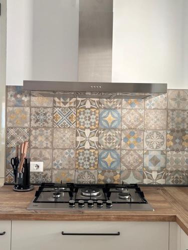 a kitchen with a stove and a tiled wall at Ai piedi del Morrone in Tocco da Casauria