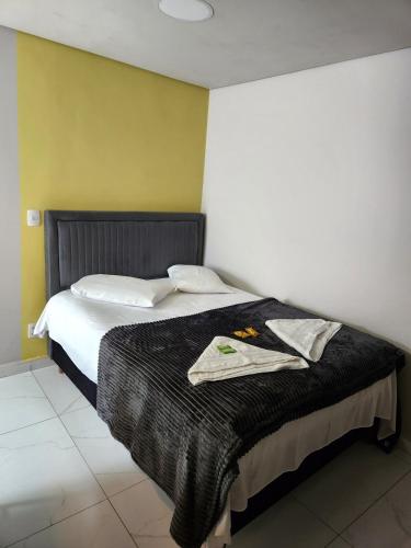 a bedroom with a bed with a black blanket at Loft Moderno- Centro Histórico in São João del Rei