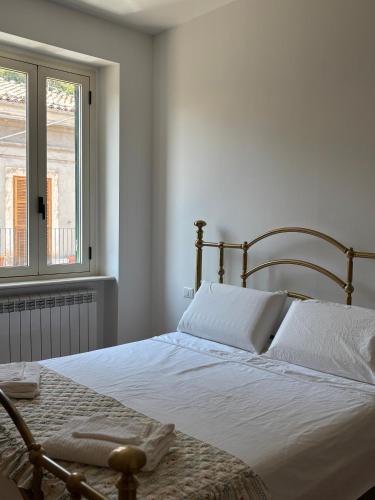 a bedroom with a bed with white sheets and a window at Ai piedi del Morrone in Tocco da Casauria