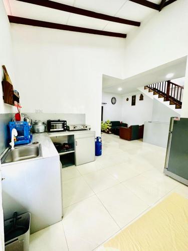 a white kitchen with a sink and a counter at Dinsara Villa Mirissa,Kamburugamuwa in Kamburugamuwa