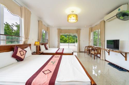 a hotel room with two beds and a television at Lumiere Family Village Ba Vì in Ba Vì