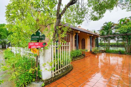 a house with a fence and a sign in front of it at Lumiere Family Village Ba Vì in Ba Vì