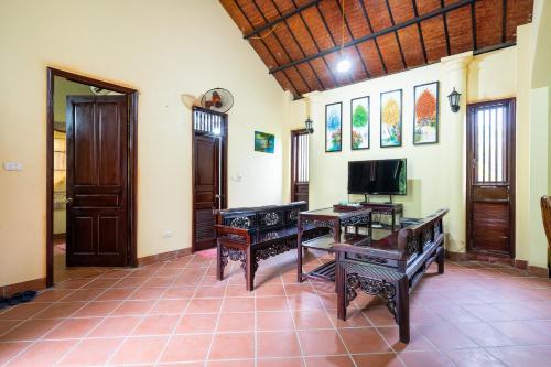 a living room with two benches and a television at Lumiere Family Village Ba Vì in Ba Vì
