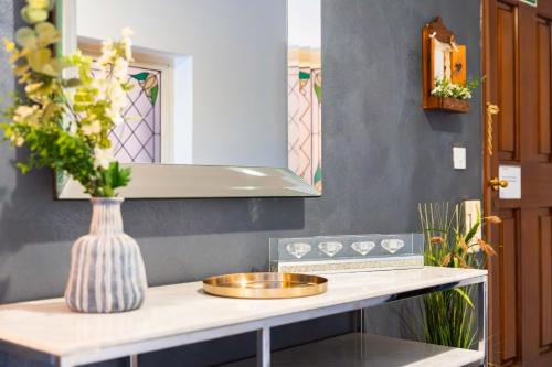 een aanrecht met een wastafel en een vaas met bloemen bij Top Location - 2BR Seafront & Steps from Ferry by ArcoBnb in Sliema