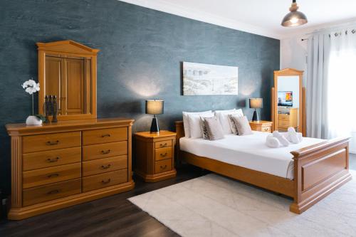 a bedroom with a large bed with a dresser and a bedsenalsenalsenal at Top Location-2BR Seafront & Steps from Ferry by Arco Collection in Sliema