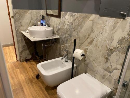 a bathroom with a white sink and a toilet at Studio O F 2 in Leonforte