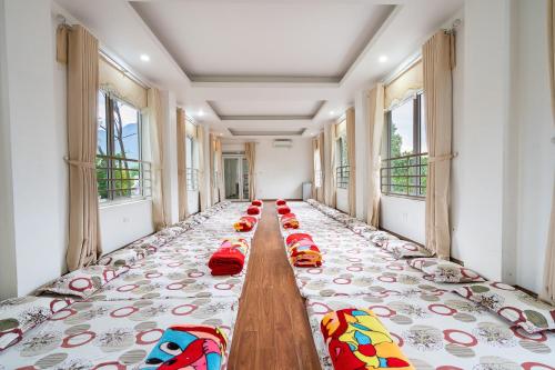 a row of beds in a room with windows at Lumiere Family Village Ba Vì in Ba Vì