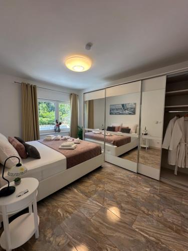 a bedroom with two beds and a large window at Appartement Ellara Penthouse in Žrnovo